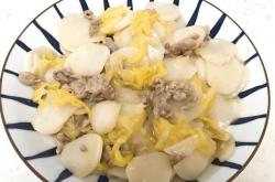 The method of stir frying rice cake with shredded cabbage and pork