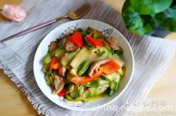 The method of stir frying pork slices with green and red peppers and zucchini