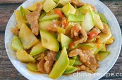 The method of stir frying pork slices with tomato and zucchini