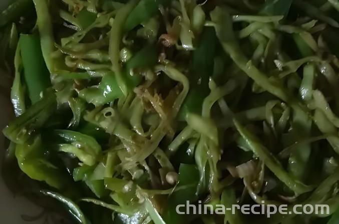 The method of stir frying pork ear and green beans with chili pepper