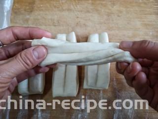 霜糖油条,用手捏着两端拉成长条，可以稍微拧一下。