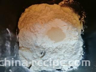甜味面包卷,再加入高筋面粉，在面粉中间挖个小洞，加入干酵母，用面粉把干酵母盖起来，启动面包机的“自动和面”程序15分钟。