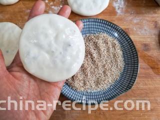 梅干菜肉烧饼,将包好的饼坯按扁，一面薄薄刷一层清水。