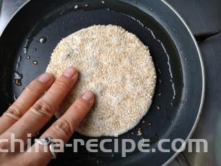 梅干菜肉烧饼,平底锅中适量油烧热，放入饼坯用手轻将边上向外压一压，中小火慢烙。