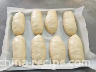 椰蓉奶油面包,放入垫有油纸的烤盘中，再次发酵两倍大，手轻压边缘，有一个印但是能慢慢回弹的状态就可以