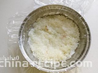 糯米红豆糕,用一个碗或其他喜欢的容器，在容器里铺一层保鲜膜，在碗底铺一层放凉的糯米饭，用手压实。