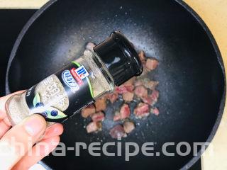 黑椒牛肉披萨,翻炒变色后，撒上少许黑胡椒粉，继续翻炒至牛肉粒变色就可以关火