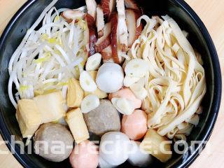 砂锅米线,在米线上放入豆芽、香菇、豆皮、各种丸子、大蒜。