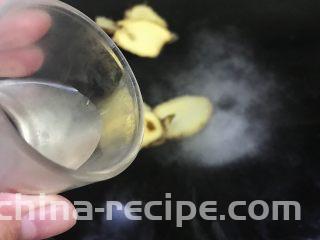 五花肉香焖田螺,锅内水烧开后加入生姜片 食盐和白酒