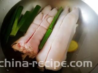 五香卤猪蹄,猪蹄对半切（只切开肉皮），冷水下锅，放入姜片和葱段。