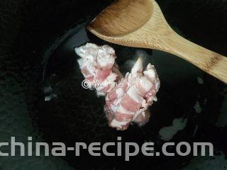 泡菜培根炒年糕,起油锅，先把培根放入，煸炒几下。