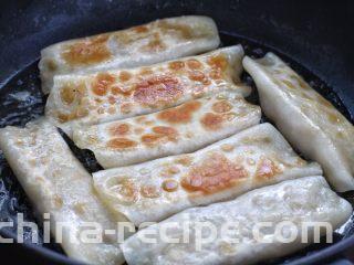 脆底猪肉洋葱锅贴,待锅内噼啪作响时将锅贴翻面，再淋入两汤匙清水，继续小火煎至水分蒸发干即可