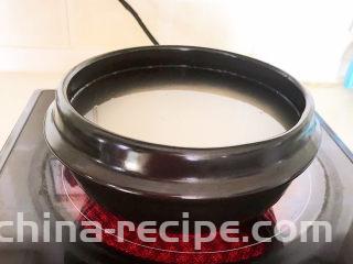 鲜虾砂锅粥,加入冷水，加入2滴玉米油，大火烧开后小火慢烧20分钟