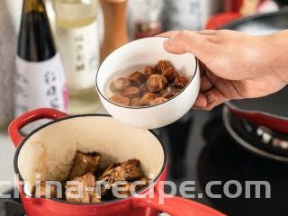 梅香秋意小排,将泡好的话梅水和其中的话梅一起倒入铸铁锅中。