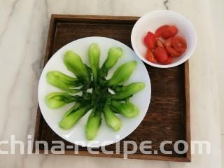 油菜炒虾仁,油菜摆入盘中  圣女果对半切开