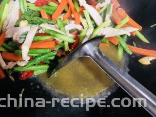 芦笋炒肉片,翻炒均匀后加入料酒拌匀，再加入适量开水煮一下，使各个味道融合。
