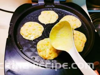鲜虾玉米饼,煎烤机刷油预热，用勺子倒入面糊。