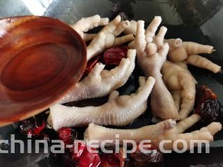 香辣卤鸡爪,倒入一勺料酒翻炒去腥。