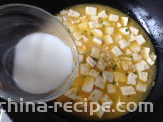 金沙豆腐,稍微煮两分钟转小火，撒点白胡椒粉，再慢慢倒入水淀粉，并用锅铲轻推豆腐，使汤汁变得略微粘稠即可