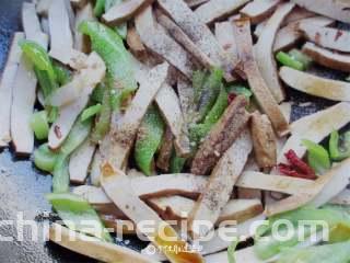 青椒炒豆干,再倒入适量生抽，盐，鸡精，五香粉，炒几下就可以了
