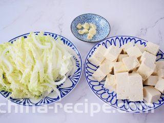 白菜豆腐,白菜洗净切成条状，豆腐切成小块，我切的是正方形的，方便后面炒不易断，蒜切片