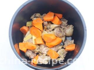 山药香菇玉米土鸡汤,鸡肉连同姜片一起放入锅中，加上胡萝卜。