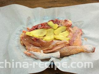 珐琅锅盐焗鸡,鸡肉两面均匀抹上盐焗鸡粉，摊开油纸，放入鸡肉，将姜片铺在鸡肉上面