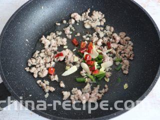 酱香干煸豆角,肉末变色后，放入葱、姜、蒜、干辣椒、花椒进行翻炒。