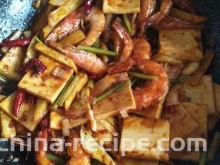 干锅香辣虾,最后放入炸好的虾和土豆条，让底料均匀裹在食材上，放少许鸡精，少许糖，炒匀即可出锅。