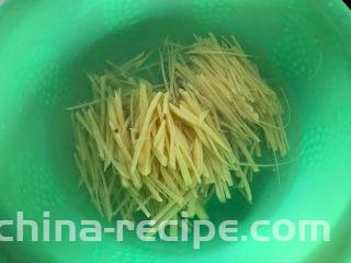 蒜香酸辣土豆丝,一边切一边将切好的土豆丝放入清水里面