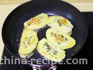 蛋煎馒头片,
翻面后，另一面也撒些黑芝麻，继续煎至金黄色即可