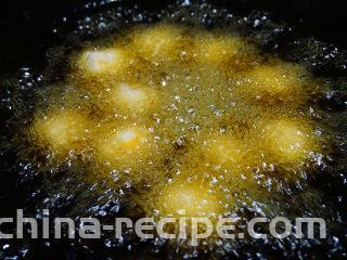 咸蛋豆腐球,锅内倒油烧热至7成时，下入搓好的蛋黄豆腐球，用中火炸
叨叨叨：豆腐球刚下锅的时候不要搅动，以免破坏其形状，待定型后用铲子轻轻搅动