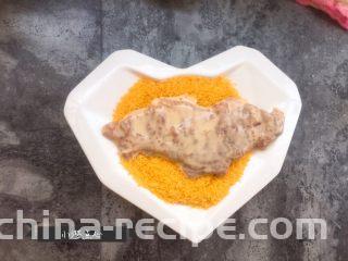 超级酥脆的炸猪排,沾满面糊的猪排，放入面包糠中，用手压实猪排上的面包糠，这样最后炸出的猪排，味道会更好。 