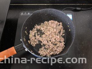 香菇肉末蒸豆腐,倒入肉末炒散。