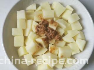 香酥排骨蒸土豆,把刚才排骨料理碗里的剩余酱料和蒜蓉倒进土豆里