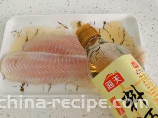 清蒸巴沙鱼柳,在姜丝上面放上鱼柳，加入料酒。