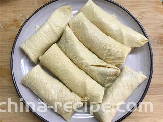 豆腐皮包肉,然后把豆腐皮包起来，全部做好后码入盘子中。