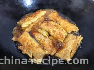 豆腐皮包肉,另取一锅，倒入适量水后加入生抽调味后把煎好的豆皮肉卷放入锅中。