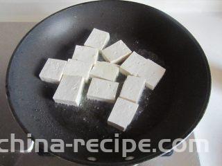 雪菜肉末烧豆腐,烧热锅，放少许油， 将切成小块的豆腐下去煎；