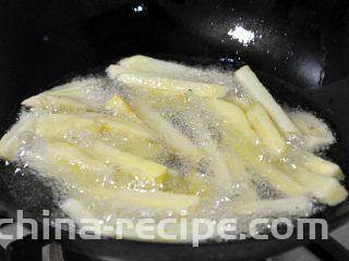 香辣干锅兔,锅中热油，倒入控干水份的土豆条，炸至金黄色。