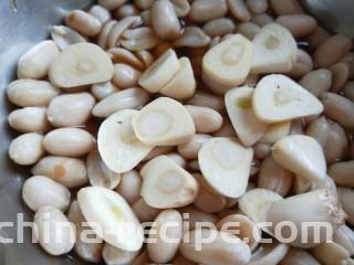 醋泡花生米,蒜去皮切片放入花生里。