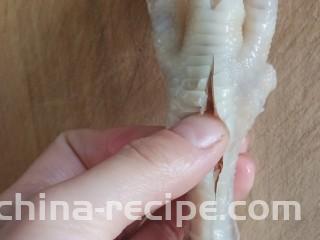 无骨蒜香鸡爪,用刀在鸡爪背部下端划一刀长长的口，用大拇指沿着这个刀口从上至下划一遍，使肉和骨头分离开，如图