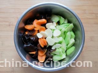 黄瓜拌木耳,将处理好的黄瓜、胡萝卜和木耳一起放入盆里，放上蒜片。