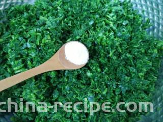 蒸苜蓿菜饼,放入盆里，加入食用碱抓匀。