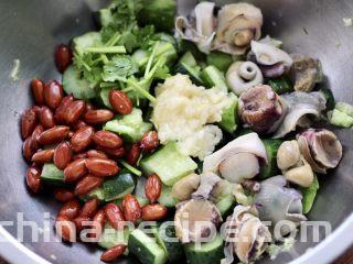 温拌海螺,取一个大一点的容器，把黄瓜和花生米，海螺和蒜泥，香菜放入盆里。