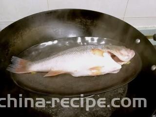 粤式清蒸鲈鱼,锅里烧开水，放入鲈鱼，盖盖子蒸7分钟。